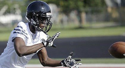 Lawrence High School senior Ekow Boye-Doe (12) participates in pass catching drills during a summer football practice Wednesday at LHS.