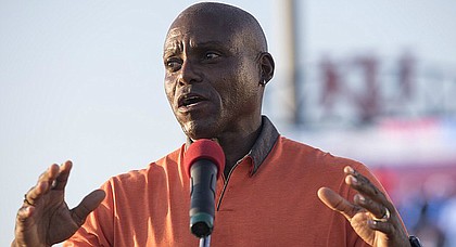 Olympic gold medalist Carl Lewis speaks to Junior Olympic athletes at Rock Chalk Park on Tuesday night during the opening ceremonies.