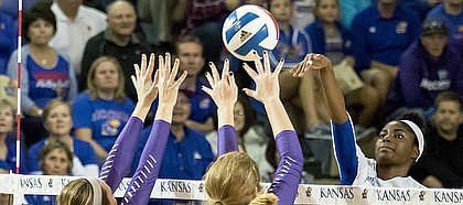 Junior Right Side Hitter Kelsie Payne strikes the ball over the Kansas State defenders, Macy Flowers (12) and Alyssa Schultejans (3), Wednesday night in the Horejsi Center.