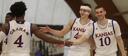 Kansas guard Devonte' Graham, left, is congratulated by teammates Mitch Lightfoot, center, and Sviatoslav Mykhailiuk, during a basketball game in Rome, Thursday, Aug. 3, 2017.