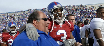 Kansas cornerback Aqib Talib walks off the field with his arm around head coach Mark Mangino following the Jayhawks' 20-15 win over Colorado Saturday at Memorial Stadium. Talib pulled in two interceptions during the 'Hawks win.
