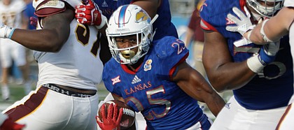 Kansas running back Dom Williams (25) squeezes between blocks in a run during the Jayhawks game against Central Michigan Saturday, Sept. 9 at Memorial Stadium.