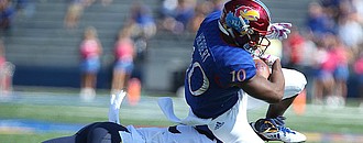 Kansas sophomore running back Khalil Herbert is taken off of his feet by a West Virginia defender during the first quarter on Saturday, Sept. 23, 2017 at Memorial Stadium.