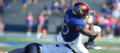 Kansas sophomore running back Khalil Herbert is taken off of his feet by a West Virginia defender during the first quarter on Saturday, Sept. 23, 2017 at Memorial Stadium.