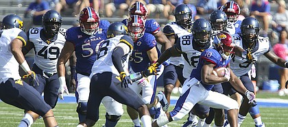 Kansas running back Khalil Herbert (10) tries to break away from the West Virginia defense during the first quarter on Saturday, Sept. 23, 2017 at Memorial Stadium.