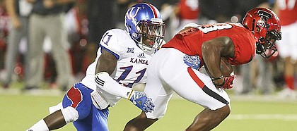 Kansas linebacker Mike Lee (11) tries to bring down Texas Tech wide receiver Cameron Batson (13) during the third quarter on Thursday, Sept. 29, 2016 at Jones AT&T Stadium in Lubbock, Texas.
