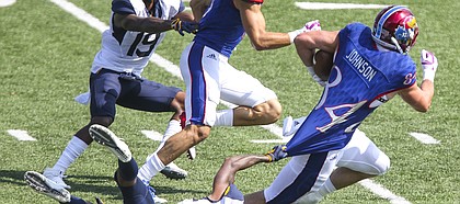 West Virginia safety Derrek Pitts (1) hangs onto the shirttail of Kansas tight end Ben Johnson (84) after a catch during the fourth quarter on Saturday, Sept. 23, 2017 at Memorial Stadium.