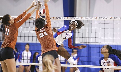 Kansas middle blocker Mmachi Nwoke (9) has a shot blocked by Texas outside hitter Lexi Sun (11) and Texas middle blocker Chiaka Ogbogu (21) during the second set on Wednesday, Oct. 11, 2017 at Horejsi Center.