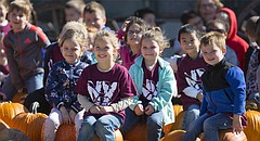 Kindergartners from Northview Elementary in Olathe squat down on a gathering of pumpkins for a class picture following a tour at Schaake's Pumpkin Patch, 1791 North 1500 Road, on Tuesday, Oct. 17, 2017.