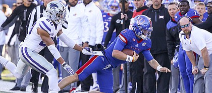 Kansas quarterback Carter Stanley (9) is shoved out of bounds by Kansas State defensive back Denzel Goolsby (20) during the third quarter on Saturday, Oct. 28, 2017 at Memorial Stadium.