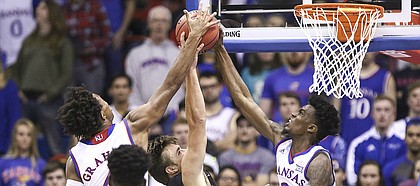 Kansas guard Lagerald Vick (2) and Kansas guard Devonte' Graham, left, stuff a shot from Fort Hays State forward Hadley Gillum (4) during the first half, Tuesday, Nov. 7, 2017 at Allen Fieldhouse.