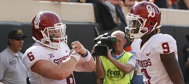 Oklahoma quarterback Baker Mayfield (6) celebrates a touchdown against Oklahoma State with teammate CeeDee Lamb (9) in the first half of an NCAA college football game in Stillwater, Okla., Saturday, Nov. 4, 2017. (AP Photo/Sue Ogrocki)
