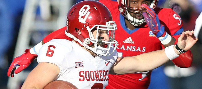 Oklahoma quarterback Baker Mayfield (6) looks to scramble as Kansas defensive tackle Jacky Dezir (54) closes in during the second quarter on Saturday, Nov. 18, 2017 at Memorial Stadium.