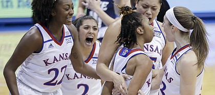 KU teammates swarm around Kansas junior guard Christalah Lyons after a basket in the first half of the Jayhawks' 73-65 win over Rice at Allen Fieldhouse on Sunday.