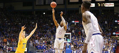 Kansas guard Devonte' Graham (4) puts up a three against Toledo guard Jaelan Sanford (13) during the first half on Tuesday, Nov. 28, 2017 at Allen Fieldhouse.