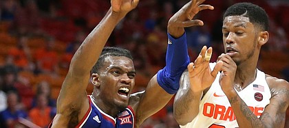 Kansas guard Lagerald Vick (2) kicks a pass out to the wing while defended by Syracuse guard Frank Howard (23) during the second half, Saturday, Dec. 2, 2017 at American Airlines Arena in Miami.