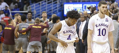 Kansas guard Devonte' Graham (4) and Kansas guard Sviatoslav Mykhailiuk (10) make their way off of the court as the Arizona State Sun Devils celebrate their 95-85 win over the Jayhawks on Sunday, Dec. 10, 2017 at Allen Fieldhouse.