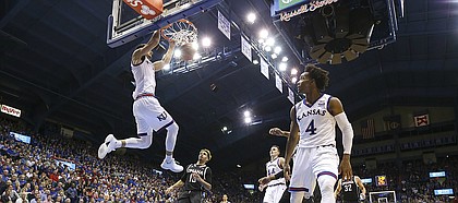 Kansas guard Sam Cunliffe (3) throws down a dunk off of a lob from Kansas guard Devonte' Graham (4) during the second half on Monday, Dec. 18, 2017 at Allen Fieldhouse.