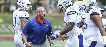 Kansas offensive line coach Zach Yenser yells at Kansas offensive lineman Chris Hughes (76) as he heads to the sidelines during the second quarter on Saturday, Sept. 16, 2017 at Peden Stadium in Athens, Ohio.