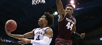 Kansas guard Devonte' Graham (4) swoops under the bucket for a shot against Texas A&M forward Robert Williams (44) during the second half, Saturday, Jan. 27, 2018 at Allen Fieldhouse.
