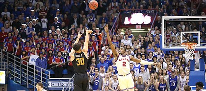 Kansas guard Lagerald Vick (2) lunges to defend against a three from Oklahoma State guard Jeffrey Carroll (30) during the second half, Saturday, Feb. 3, 2018 at Allen Fieldhouse.