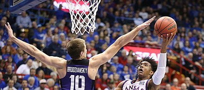 Kansas guard Devonte' Graham (4) maneuvers for a shot against TCU forward Vladimir Brodziansky (10) during the first half on Tuesday, Feb. 6, 2018 at Allen Fieldhouse.