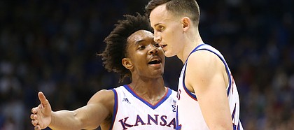 Kansas guard Devonte' Graham (4) talks with Kansas forward Mitch Lightfoot (44) during a break in action in the second half on Tuesday, Feb. 6, 2018 at Allen Fieldhouse.