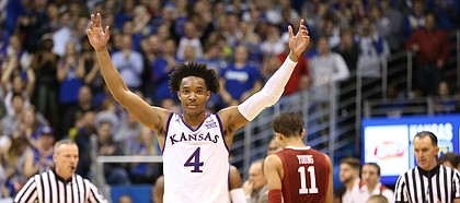 Kansas guard Devonte' Graham (4) raises up the Fieldhouse during a timeout in the second half, Monday, Feb. 19, 2018 at Allen Fieldhouse.