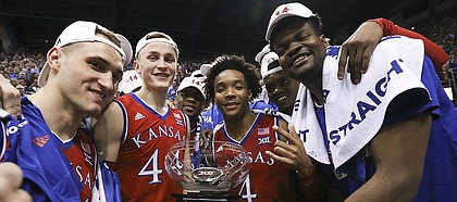 The Jayhawks come together with the Big 12 conference championship trophy following their 80-70 win over Texas on Monday, Feb. 26, 2018 at Allen Fieldhouse. The win gave the Jayhawks an outright win of their 14th-straight Big 12 Conference title.
