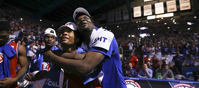 Kansas center Udoka Azubuike gives a hug to senior guard Devonte' Graham while the team watches a highlight video following their 80-70 win over Texas on Monday, Feb. 26, 2018 at Allen Fieldhouse. The win gave the Jayhawks an outright win of their 14th-straight Big 12 Conference title.