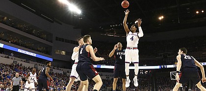 Kansas guard Devonte' Graham (4) puts up a floater over Penn guard Darnell Foreman (4) during the first half, Thursday, March 15, 2018 at Intrust Bank Arena in Wichita, Kan.