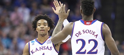 Kansas guard Devonte' Graham (4) and Kansas forward Silvio De Sousa (22) slap hands after connecting on a lob jam during the first half, Friday, March 23, 2018 at CenturyLink Center in Omaha, Neb.