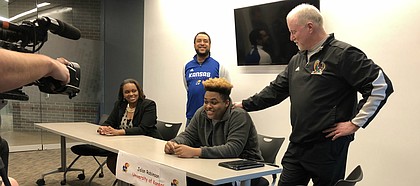 Jalan Robinson, joined by coach Bob Lisher, signs with KU football at a ceremony at Free State.