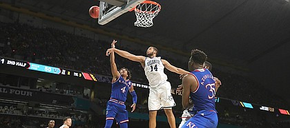 Kansas guard Devonte' Graham (4) has a shot rejected by Villanova forward Omari Spellman (14) during the second half, Saturday, March 31, 2018 at the Alamodome in San Antonio, Texas.