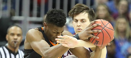 Kansas forward James Sosinski (55) tries to strip a ball from Oklahoma State forward Yankuba Sima (35) during the first half, Thursday, March 8, 2018 at Sprint Center in Kansas City, Mo.