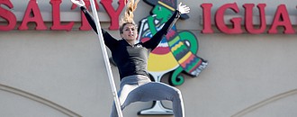 Kristin Hixson clears the bar on a vault on her way to winning a street pole vault exhibition in the parking lot of the Salty Iguana restaurant near 6th and Wakarusa St. Thursday afternoon.