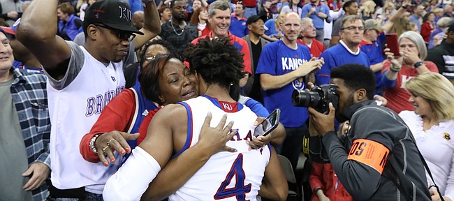 Kansas guard Devonte' Graham (4) hugs his mother as the Jayhawks celebrate a trip to the Final Four following their 85-81 overtime victory over Duke on Sunday in Omaha, Neb.