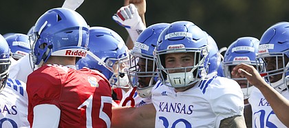Kansas linebacker Joe Dineen (29) and other players gather in for a huddle during practice on Tuesday, April 10, 2018.