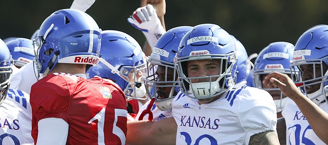 Kansas linebacker Joe Dineen (29) and other players gather in for a huddle during practice on Tuesday, April 10, 2018.