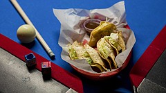 The tacos at Crimson & Brews, 925 Iowa St., consist of seasoned ground beef, potatoes and a slice of American cheese fried in a corn tortilla and then topped with lettuce and powdered white cheddar.