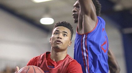 Red Team guard Devon Dotson dips under Blue Team forward Silvio De Sousa for a bucket during a scrimmage on Wednesday, June 13, 2018, at the Horejsi Family Athletics Center.