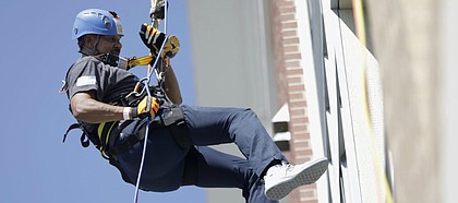 Kansas men's basketball assistant coach Kurtis Townsend rappels down the 888 Lofts, 888 New Hampshire St., in the Over the Edge fundraising event for Boys & Girls Club of Lawrence, Saturday, Aug. 25, 2018.