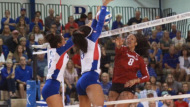 Juniors Patricia Montero (left), and Zoe Hill block a ball from Arkansas sophomore Elizabeth Pamphile. Kansas fell to Arkansas Sunday afternoon in four sets.