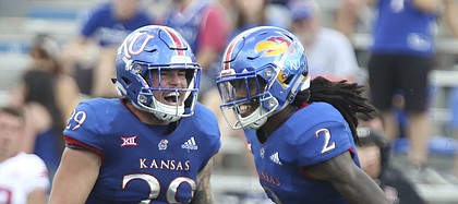 Kansas linebacker Joe Dineen Jr. (29) celebrates an interception by Kansas cornerback Corione Harris (2) during the third quarter on Saturday, Sept. 15, 2018 at Memorial Stadium.