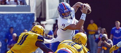 Kansas quarterback Carter Stanley (9) is tackled by West Virginia linebackers David Long Jr. (11) and Kenny Bigelow, Jr. during the first half of an NCAA college football game against Kansas in Morgantown, W. Va., Saturday Oct. 6, 2018. (Craig Hudson/Charleston Gazette-Mail via AP)