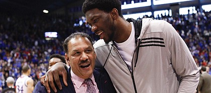 Philadelphia 76ers center Joel Embiid chats up Kansas assistant coach Kurtis Townsend on the way to the locker room following the Jayhawks' 74-64 win over Baylor on Saturday, Feb. 14, 2015 at Allen Fieldhouse.
