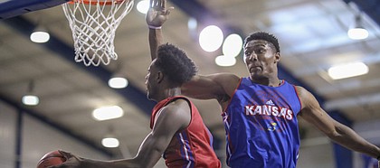 Red Team guard Marcus Garrett dips under Blue Team center David McCormack for a bucket during a scrimmage on Wednesday, June 13, 2018, at the Horejsi Family Athletics Center.