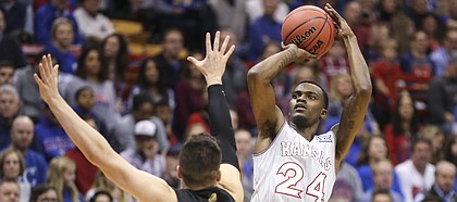 Kansas guard Lagerald Vick (24) puts up a three over Vermont guard Ernie Duncan (20) during the first half, Monday, Nov. 12, 2018 at Allen Fieldhouse.