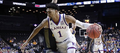 Kansas' Dedric Lawson (1) drives past Marquette's Joey Hauser (22) during the first half of an NCAA college basketball game in the NIT Season Tip-Off tournament Wednesday, Nov. 21, 2018, in New York.