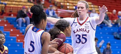 Iona's Gabrielle Joseph (21) is protecting the ball from a rebound as Kansas guard Aniya Thomas (5) and center Bailey Helgren (35) sets a trap to try to force a turnover in the first quarter on Sunday, Nov. 25, 2018 at Allen Fieldhouse.